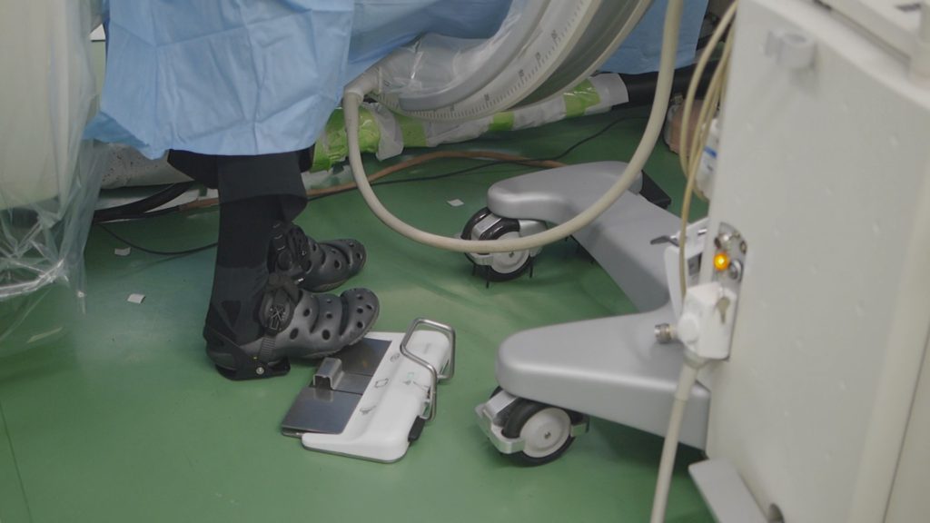 脊髄外科のオペでアルケリス装着中にフットスイッチを使用する深谷賢司先生